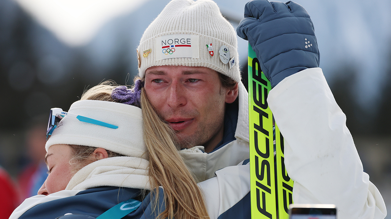 ANTHOLZ-ANTERSELVA, ITALY - FEBRUARY 10: Bronze medalist Sturla Holm Laegreid of Team Norway is embraced by Ingrid Landmark Tandrevold of Team Norway after the medal ceremony for the Men's 20km Individual on day four of the Milano Cortina 2026 Winter Olympic games at Anterselva Biathlon Arena on February 10, 2026 in Antholz-Anterselva, Italy.