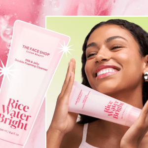 A pink background with a photo of a woman holding a cleanser bottle and smiling.